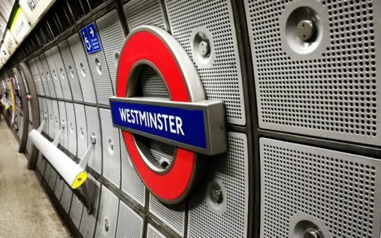 A sign for Westminster Tube Station on a platform