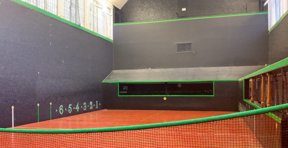 Hampton Court Palace's royal tennis court with the net in the foreground and the court's slanted roof in the background