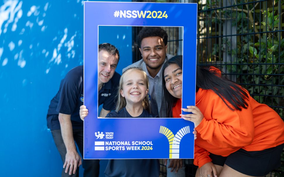 A student and staff smile for the camera