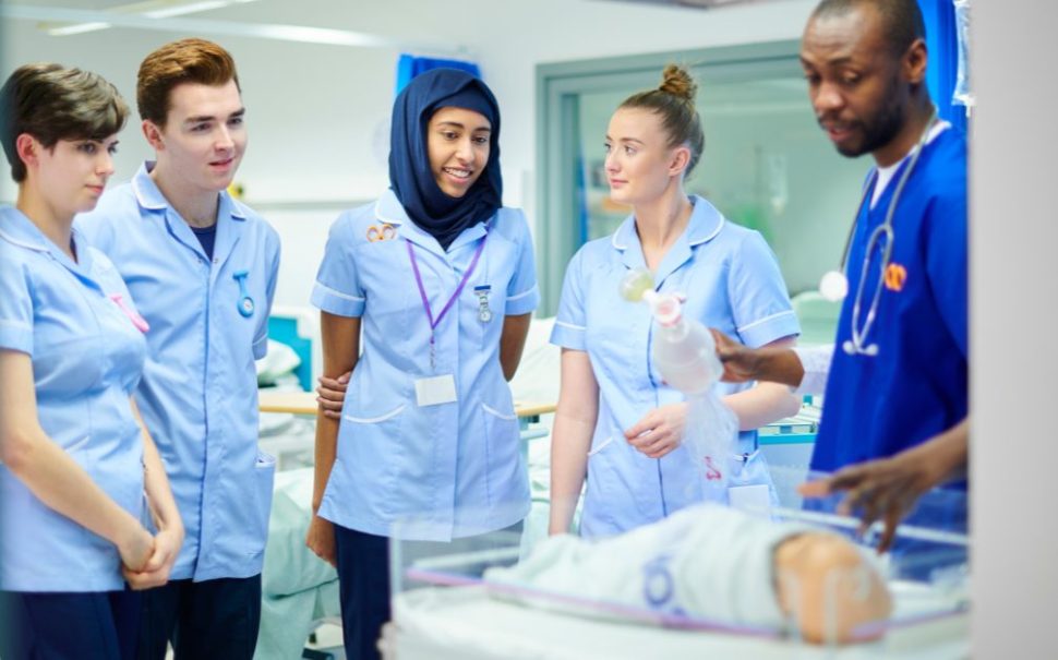 Midwifery students gather around a fake baby. The RCM is urging politicians to invest in midwives