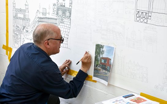 An image of Ian painting a large canvas, using a photograph for reference