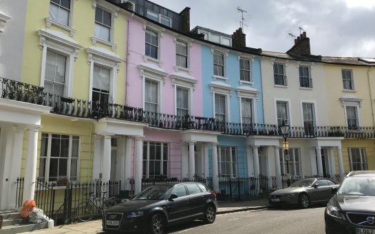 A photo of three houses in Primrose Hill which are brightly coloured around a crescent