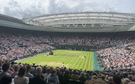 An image of Wimbledon centre court, filled with people. The court is in the centre of the photo