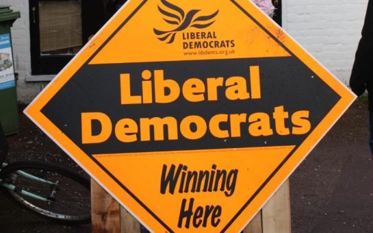 A close up of an orange sign which says Liberal Democrats winning here