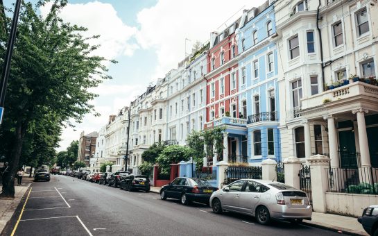 A London street with multicoloured houses with cars parked outside