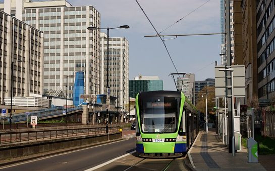 Green tram travels through Croydon