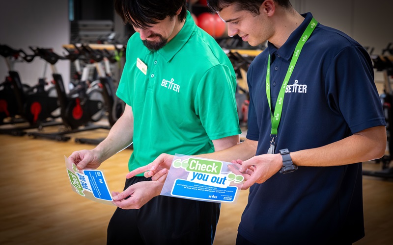 Two men with the 'Check you out' cancer awareness stickers. Picture credit: Better