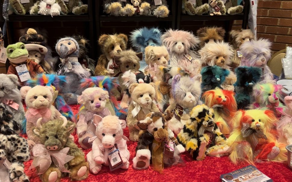 Table covered in a variety of colourful teddy bears.