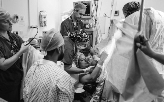 Midwife passing a woman her baby after giving birth