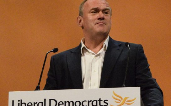 Ed Davey at a podium giving a speech