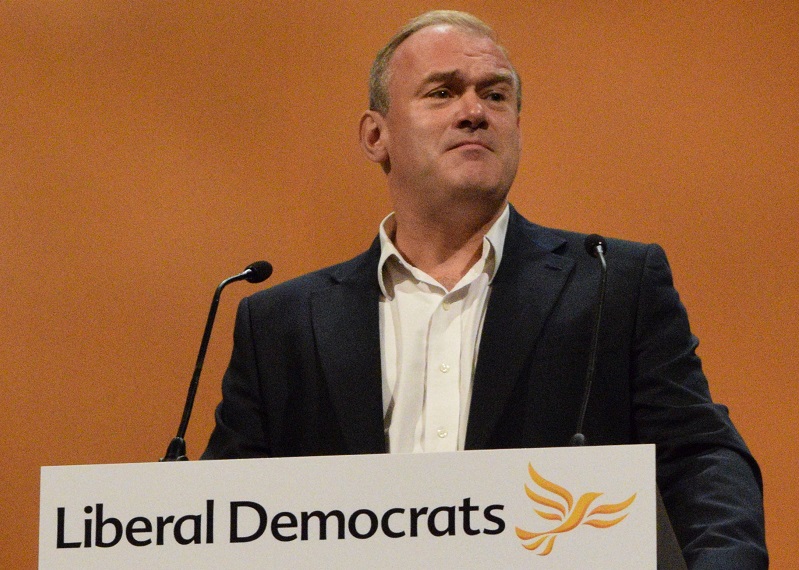 Ed Davey at a podium giving a speech