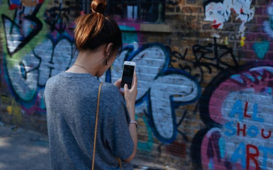 Woman takes picture of graffiti