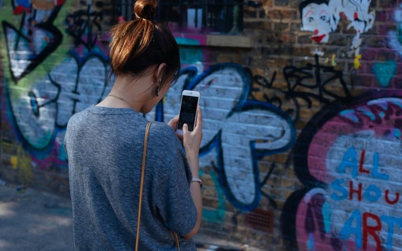 Woman takes picture of graffiti