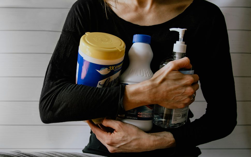 Person holding cleaning products