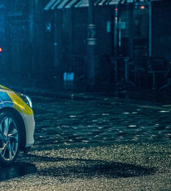 Police car on dark cobbled street