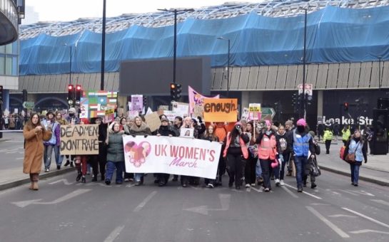 A group of protestors with signs and banners in the middle of the road