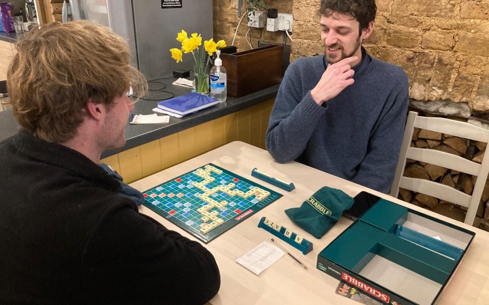 Two men play scrabble at a board game cafe