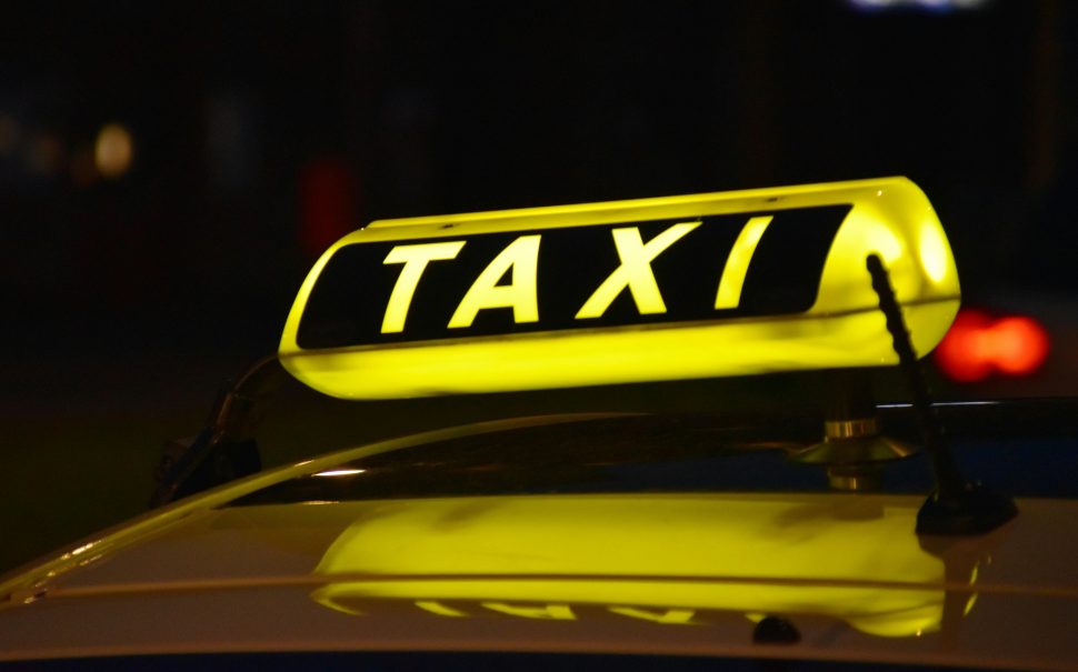 A lit up taxi sign at night