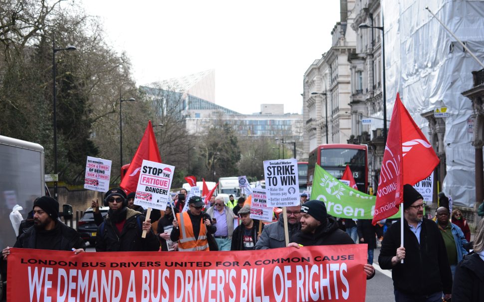 Photo of marchers in the street supporting a bus drivers' bill of rights holding up signs and a banner