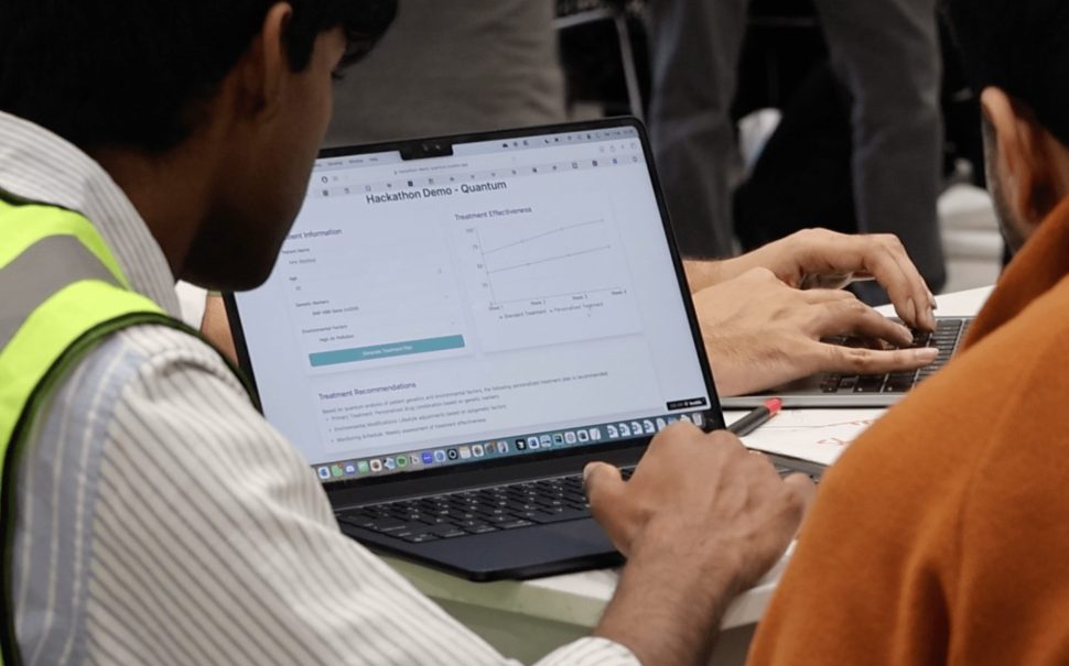 Two people sat around a laptop