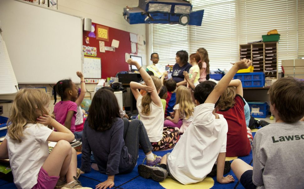 A group of children with their hands up