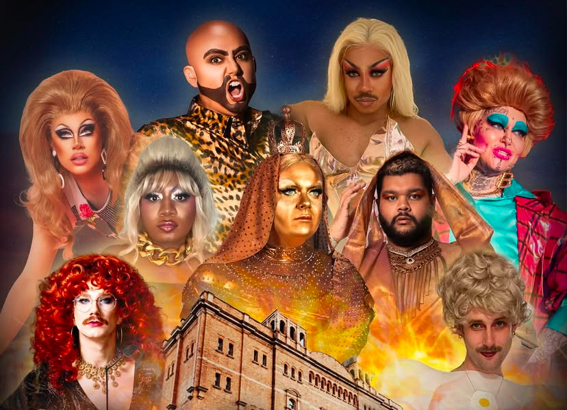 Promotional image for “EastBenders,” a drag show inspired by EastEnders, featuring a group of drag performers dressed as iconic characters from the soap. The performers are styled in dramatic wigs, bold makeup, and glamorous outfits, each embodying different EastEnders personalities. The Clapham Grand, the show’s venue, is prominently featured at the bottom of the image, engulfed in fiery effects, adding a sense of drama and excitement.