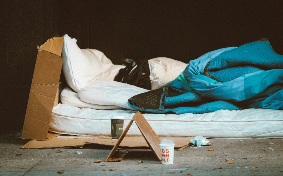 A mattress with a duvet on the street